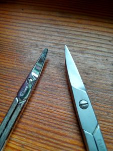 Auf der linken Seite eine Schere mit abgerundeter Spitze und rechts eine Version für Erwachsene.